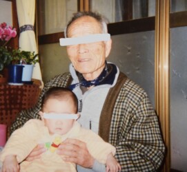 ひ孫を抱く男性高齢者